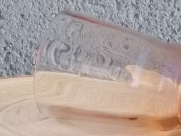 Verre à Eau, en verre soufflé teinté Rose Saumoné "Facetté". Forme évasé avec effet bourrelet au 1/4 base. Piédouche épais bombé.