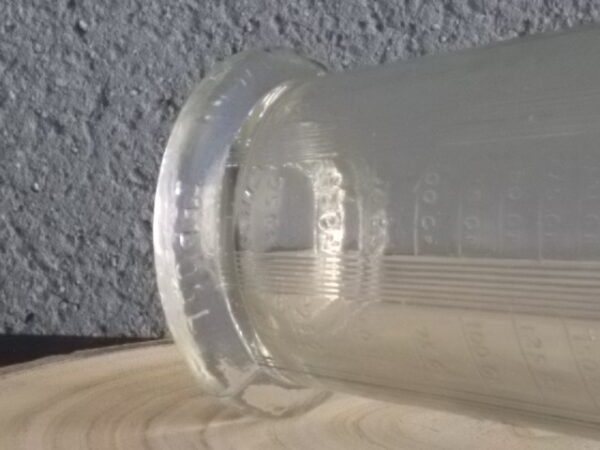 Verre doseur en verre épais translucide moulé pressé. Forme évasé sur base socle. Verre gradué contenant 300 gr. De Portieux Mougin Déposé.