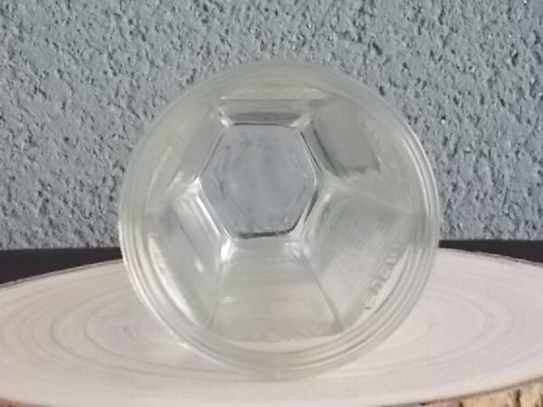 Verre doseur en verre translucide épais moulé. Forme évasé à cotes plates sur base socle Hexagonale. Graduation extérieur, et rebord épais.